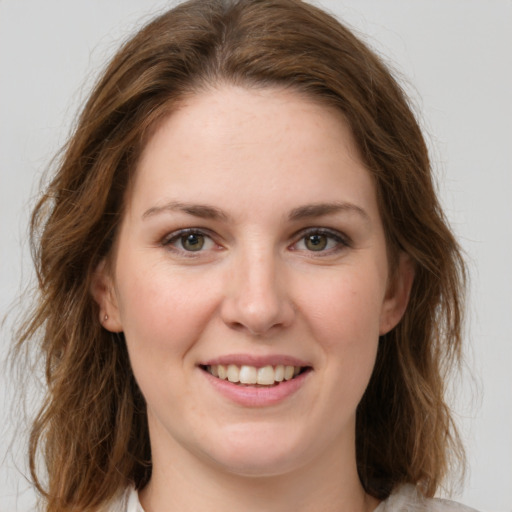 Joyful white young-adult female with medium  brown hair and green eyes