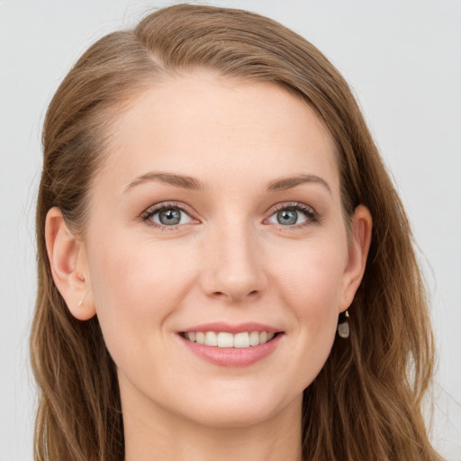 Joyful white young-adult female with long  brown hair and blue eyes