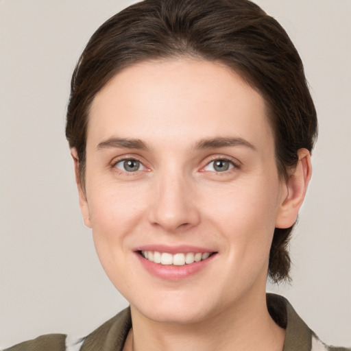 Joyful white young-adult female with medium  brown hair and grey eyes