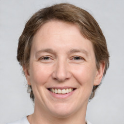 Joyful white adult female with medium  brown hair and grey eyes