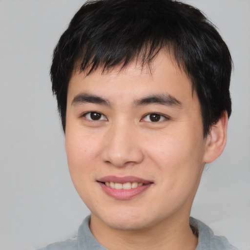 Joyful asian young-adult male with short  brown hair and brown eyes