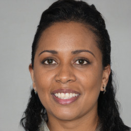Joyful black young-adult female with long  black hair and brown eyes