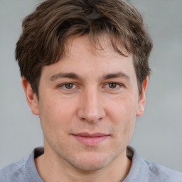 Joyful white young-adult male with short  brown hair and grey eyes