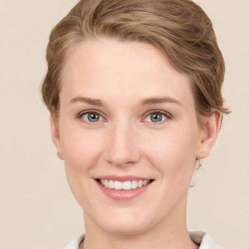 Joyful white young-adult female with short  brown hair and grey eyes