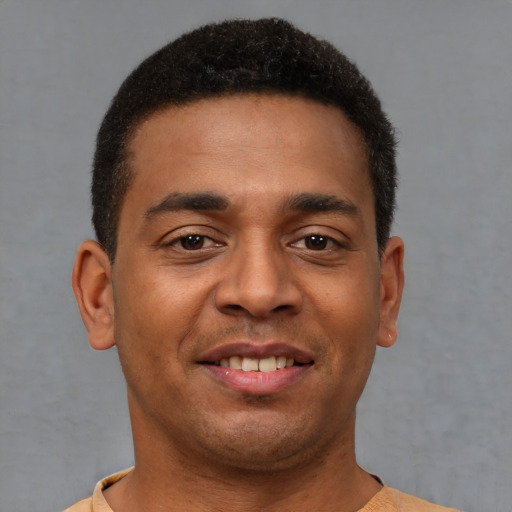 Joyful latino young-adult male with short  brown hair and brown eyes
