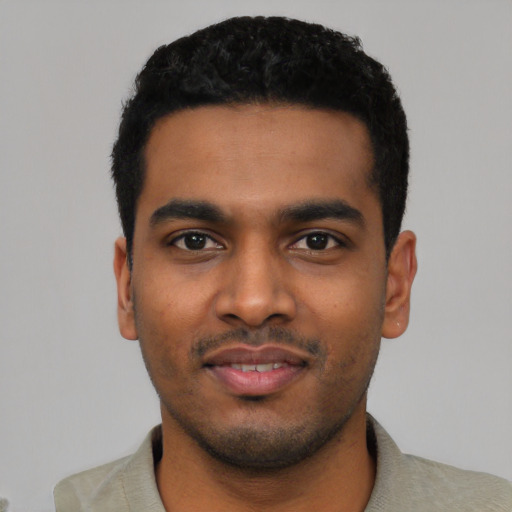 Joyful black young-adult male with short  black hair and brown eyes