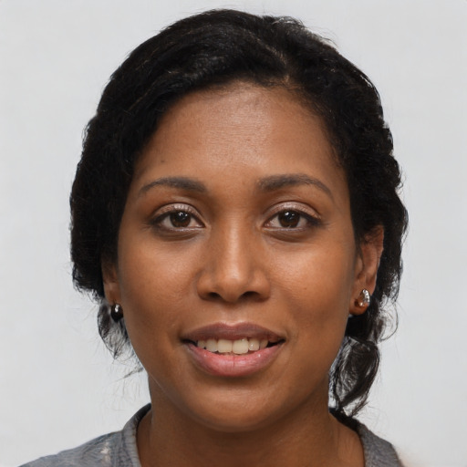 Joyful black young-adult female with short  black hair and brown eyes