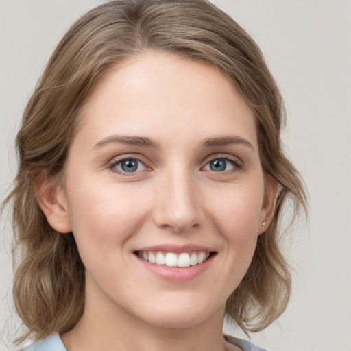 Joyful white young-adult female with medium  brown hair and blue eyes