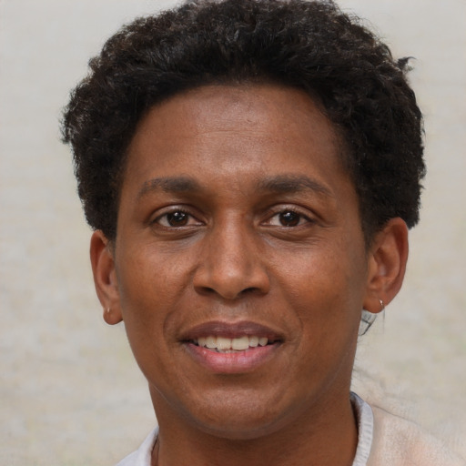 Joyful black adult male with short  brown hair and brown eyes