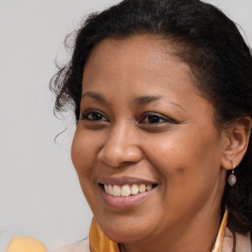 Joyful black young-adult female with long  brown hair and brown eyes