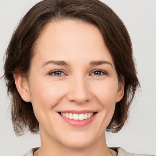 Joyful white young-adult female with medium  brown hair and brown eyes