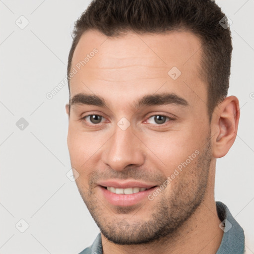 Joyful white young-adult male with short  brown hair and brown eyes