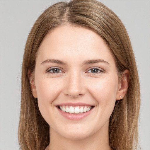 Joyful white young-adult female with long  brown hair and grey eyes