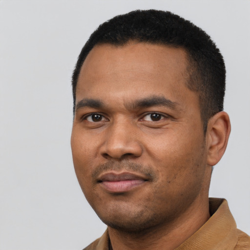 Joyful black young-adult male with short  black hair and brown eyes