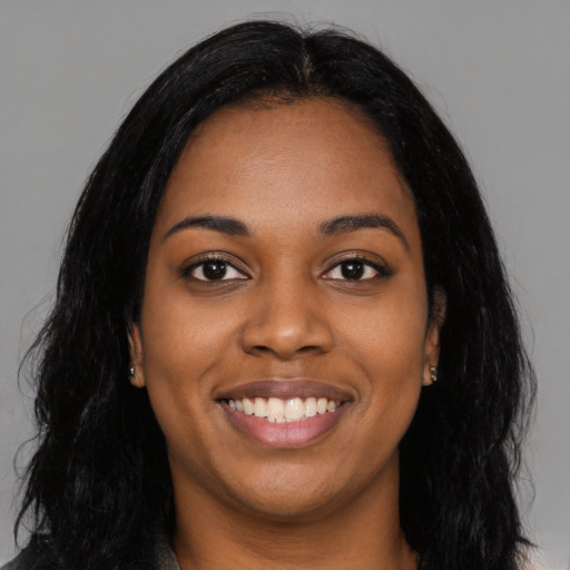 Joyful black young-adult female with long  black hair and brown eyes