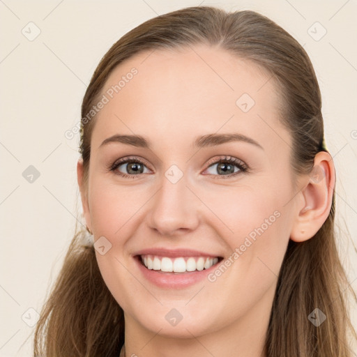 Joyful white young-adult female with long  brown hair and blue eyes