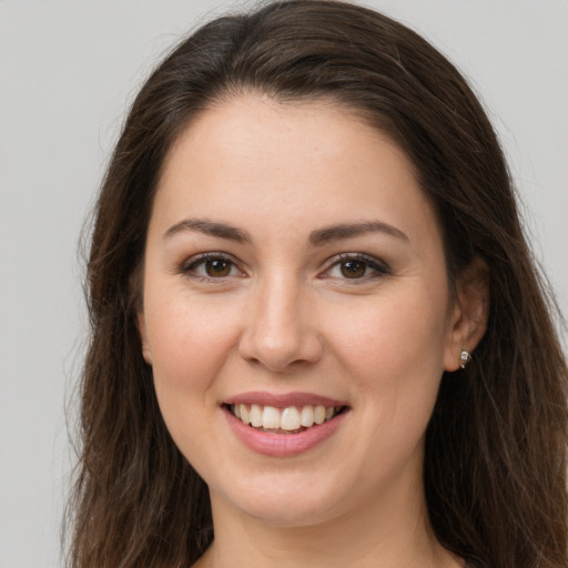 Joyful white young-adult female with long  brown hair and brown eyes