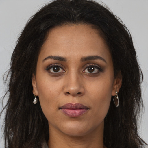 Joyful latino young-adult female with long  brown hair and brown eyes