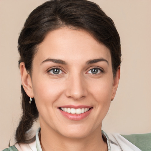 Joyful white young-adult female with medium  brown hair and grey eyes