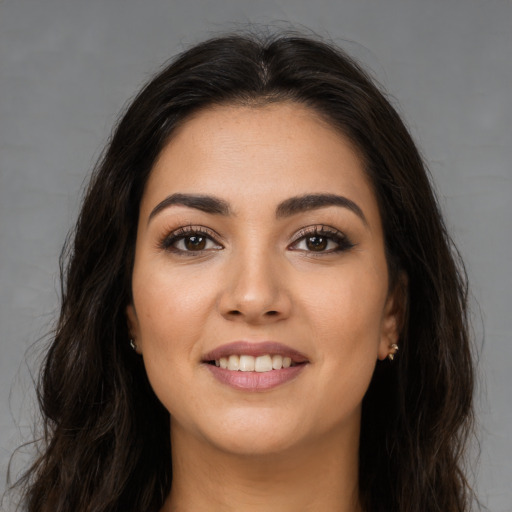 Joyful latino young-adult female with long  brown hair and brown eyes