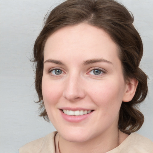 Joyful white young-adult female with medium  brown hair and blue eyes