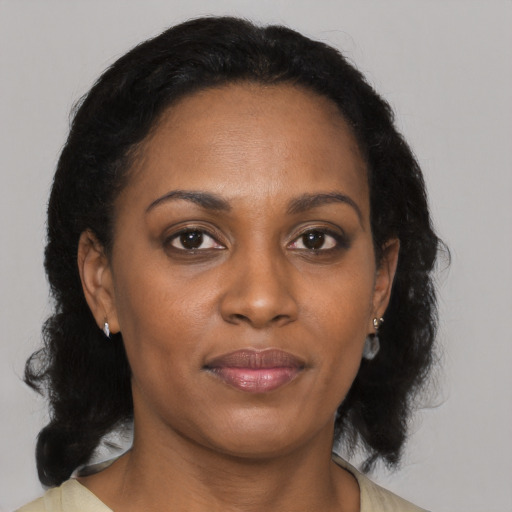 Joyful black adult female with medium  brown hair and brown eyes