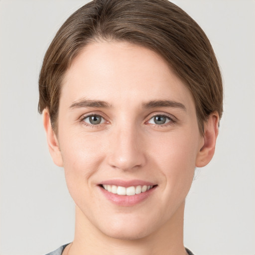 Joyful white young-adult female with short  brown hair and grey eyes