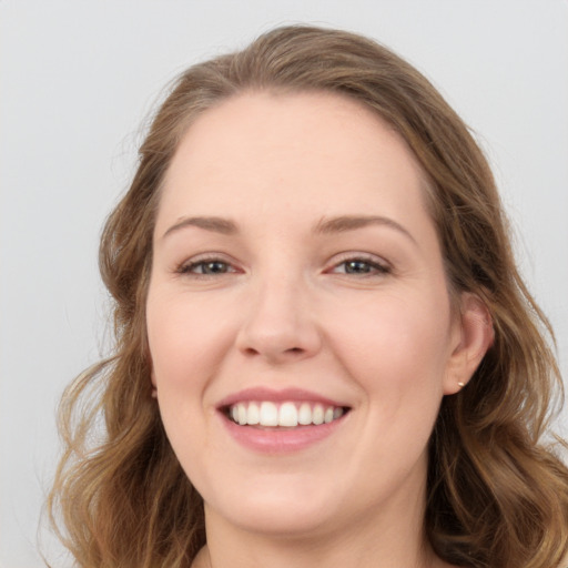 Joyful white young-adult female with long  brown hair and blue eyes