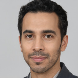 Joyful white young-adult male with short  black hair and brown eyes
