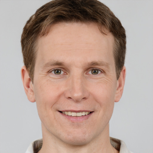 Joyful white adult male with short  brown hair and grey eyes