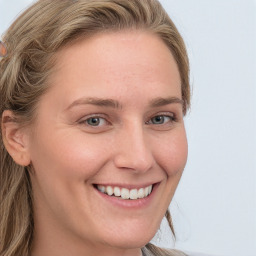 Joyful white young-adult female with long  brown hair and blue eyes