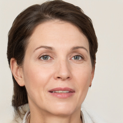 Joyful white adult female with medium  brown hair and grey eyes