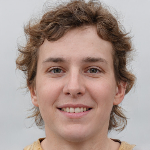 Joyful white young-adult male with medium  brown hair and grey eyes