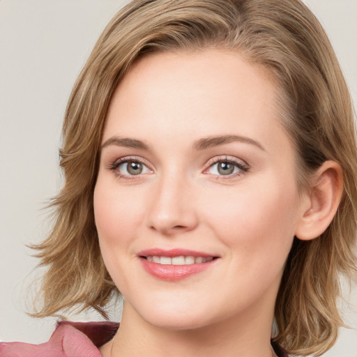 Joyful white young-adult female with medium  brown hair and blue eyes