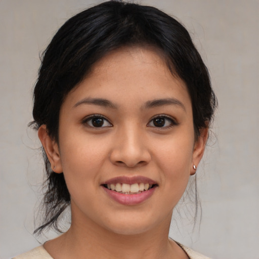Joyful latino young-adult female with medium  brown hair and brown eyes
