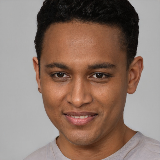 Joyful black young-adult male with short  brown hair and brown eyes