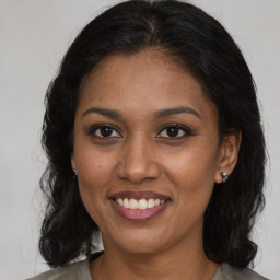 Joyful black young-adult female with medium  brown hair and brown eyes