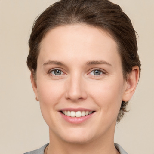 Joyful white young-adult female with short  brown hair and grey eyes