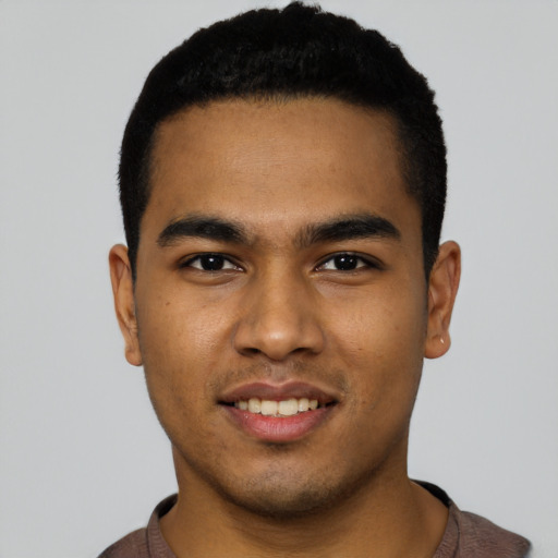 Joyful latino young-adult male with short  black hair and brown eyes