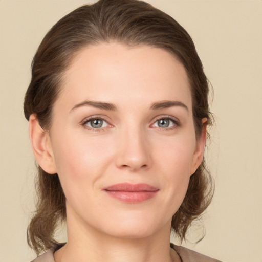 Joyful white young-adult female with medium  brown hair and grey eyes