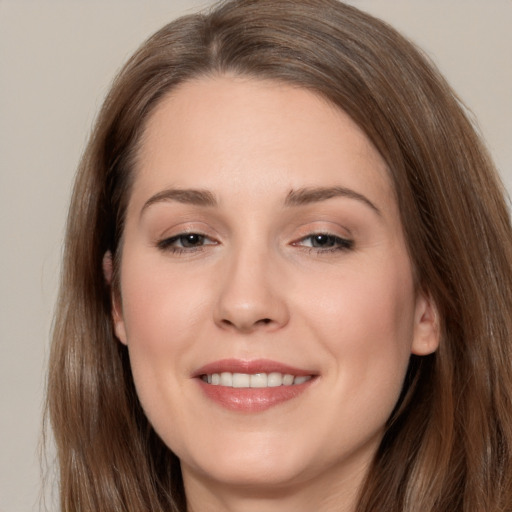 Joyful white young-adult female with long  brown hair and brown eyes