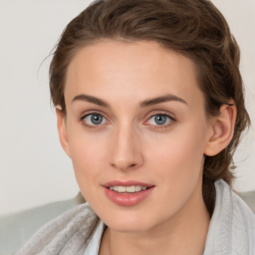 Joyful white young-adult female with medium  brown hair and grey eyes