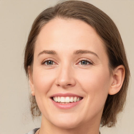 Joyful white young-adult female with medium  brown hair and grey eyes