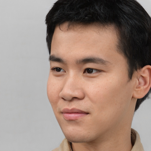 Joyful asian young-adult male with short  black hair and brown eyes