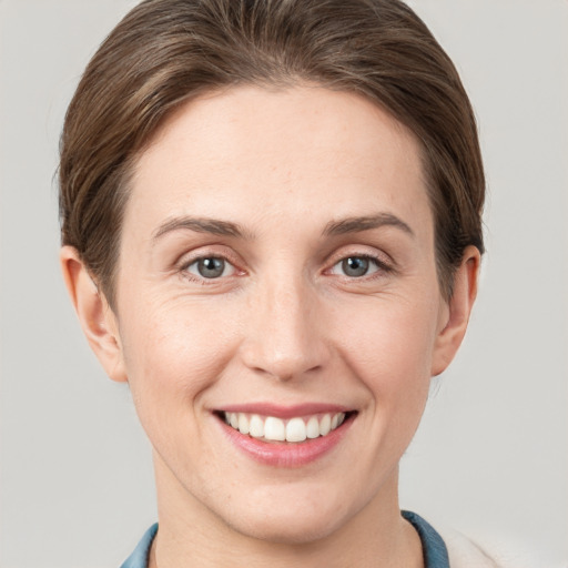 Joyful white young-adult female with short  brown hair and grey eyes