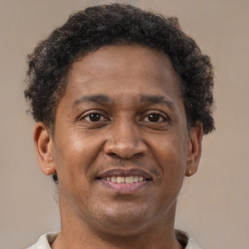 Joyful black adult male with short  brown hair and brown eyes