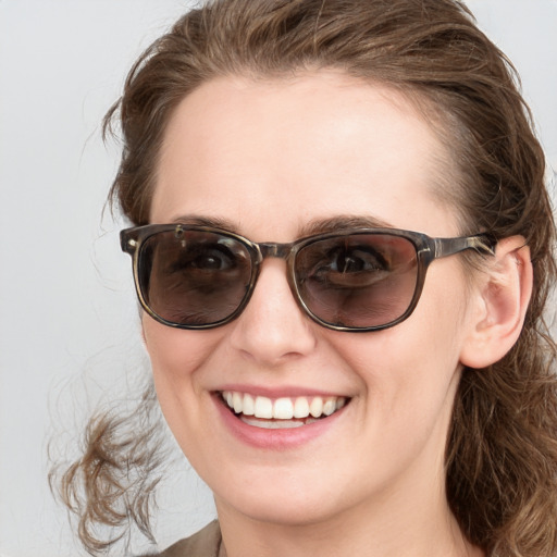 Joyful white young-adult female with medium  brown hair and blue eyes