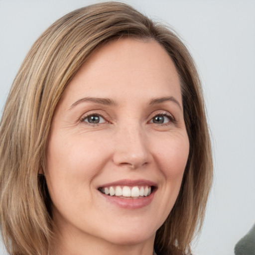 Joyful white young-adult female with medium  brown hair and green eyes