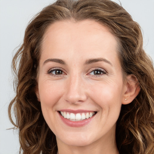 Joyful white young-adult female with long  brown hair and green eyes