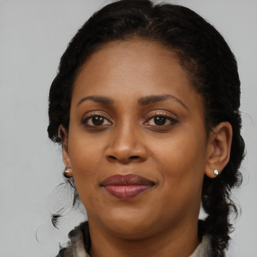 Joyful black young-adult female with long  brown hair and brown eyes